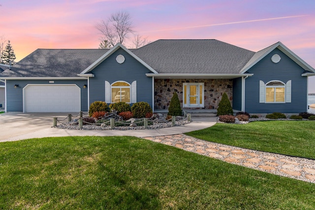 single story home featuring a garage, a yard, driveway, and a shingled roof