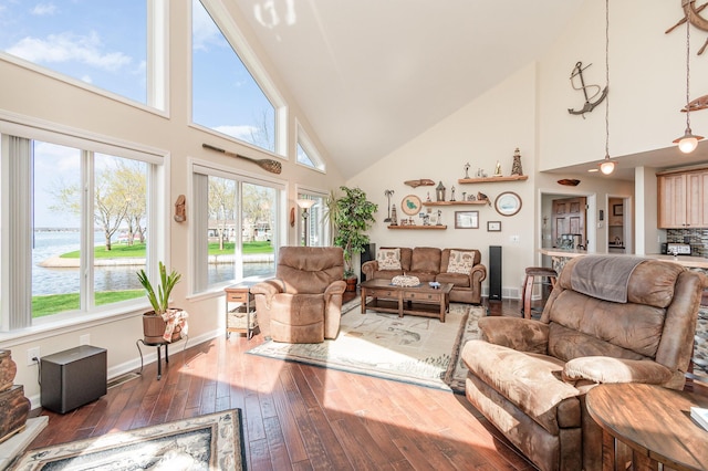 living room with baseboards, a water view, hardwood / wood-style floors, and high vaulted ceiling