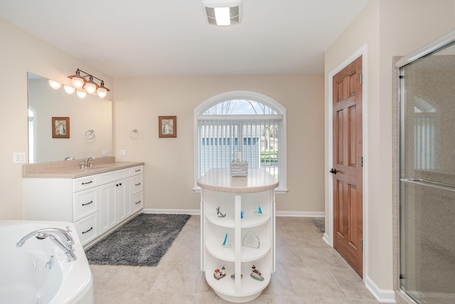 bathroom featuring baseboards, a shower stall, a bath, and vanity