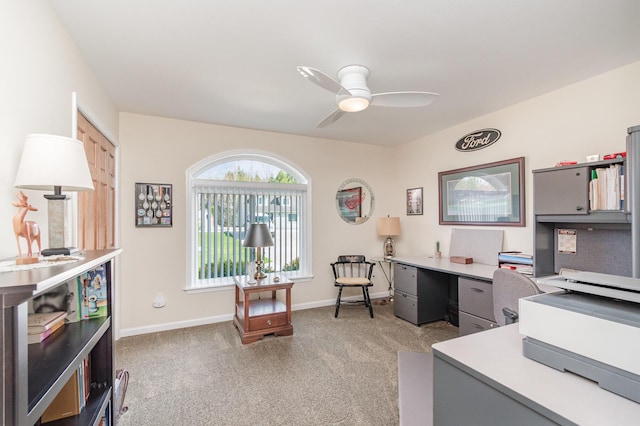 office featuring ceiling fan, light carpet, and baseboards