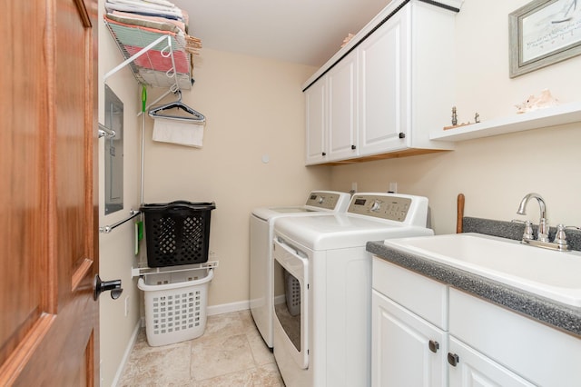 clothes washing area featuring a sink, baseboards, cabinet space, and washing machine and clothes dryer