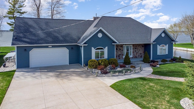 view of front of home featuring a garage, a shingled roof, concrete driveway, and a front yard