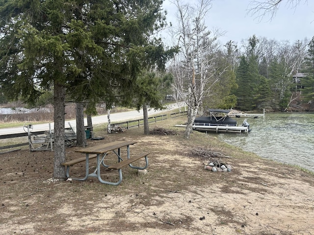 view of yard with a water view and a boat dock