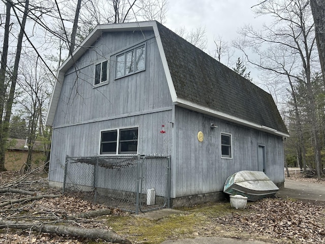 view of side of property with roof with shingles and a gambrel roof