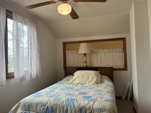 bedroom featuring a ceiling fan, vaulted ceiling, and a textured ceiling