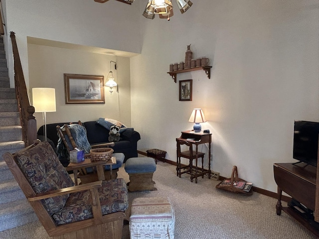 living area featuring carpet flooring, baseboards, and stairway