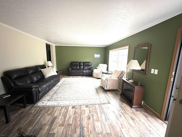 living room featuring baseboards, ornamental molding, a textured ceiling, and wood finished floors