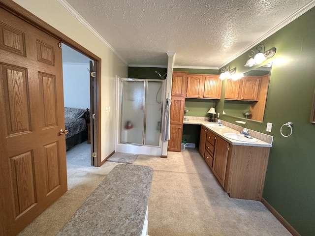 bathroom featuring double vanity, a textured ceiling, a shower stall, a sink, and ornamental molding