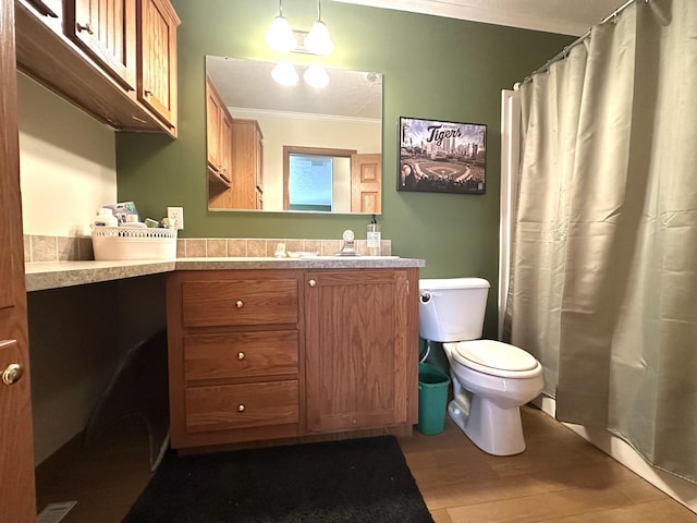 bathroom with crown molding, toilet, wood finished floors, and vanity