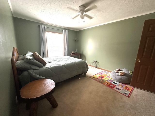 bedroom featuring carpet floors, a ceiling fan, a textured ceiling, and ornamental molding