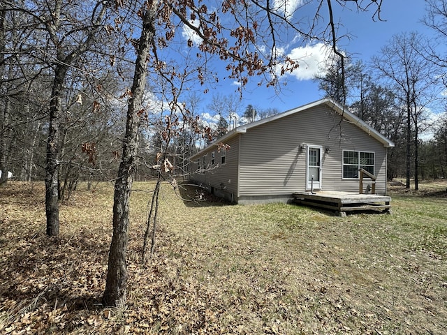 view of home's exterior with a wooden deck and a yard