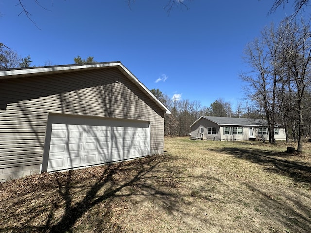 view of side of property with a garage and an outbuilding