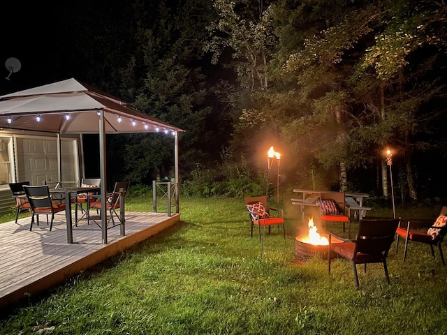 3047 Timberlane Trl, Grayling, MI 49738 - yard at twilight with a gazebo, an outdoor fire pit, a deck, and outdoor dining space