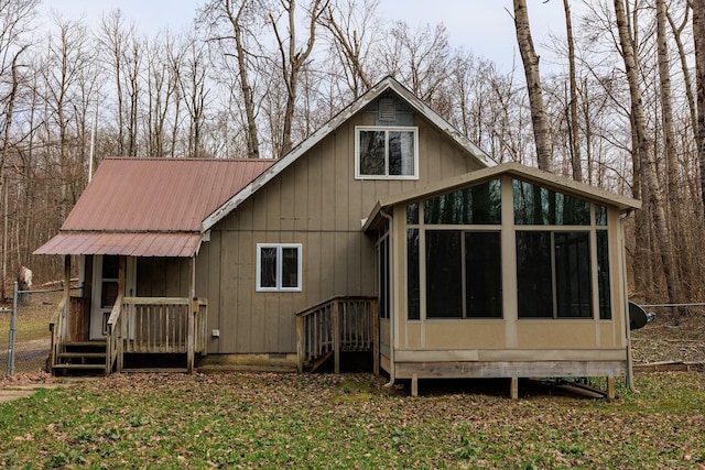 back of property featuring a sunroom and metal roof