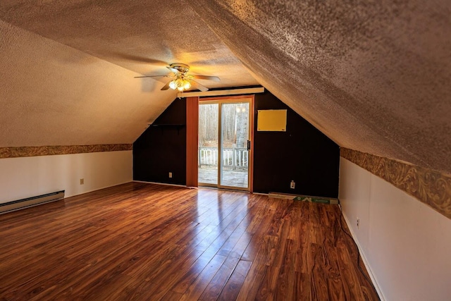 additional living space featuring wood-type flooring, a textured ceiling, vaulted ceiling, and ceiling fan