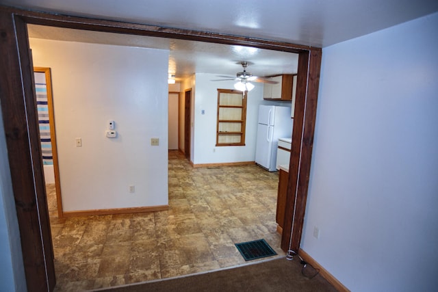 hall featuring baseboards and visible vents