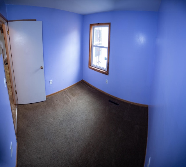 carpeted spare room featuring visible vents and baseboards