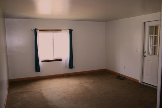 unfurnished room with baseboards and carpet