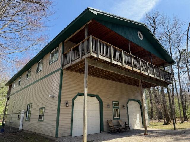 exterior space featuring an attached garage and a wooden deck