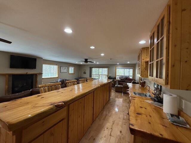 kitchen featuring a sink, wood counters, recessed lighting, open floor plan, and a ceiling fan