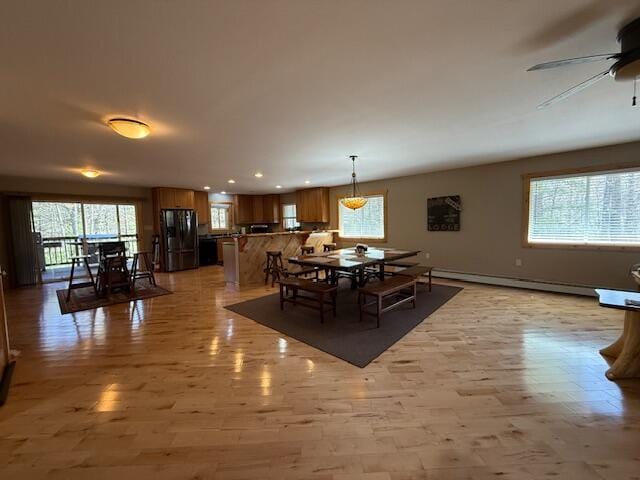 dining area featuring a ceiling fan, recessed lighting, baseboard heating, and light wood-style flooring