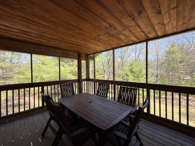 sunroom / solarium with outdoor dining area and a healthy amount of sunlight
