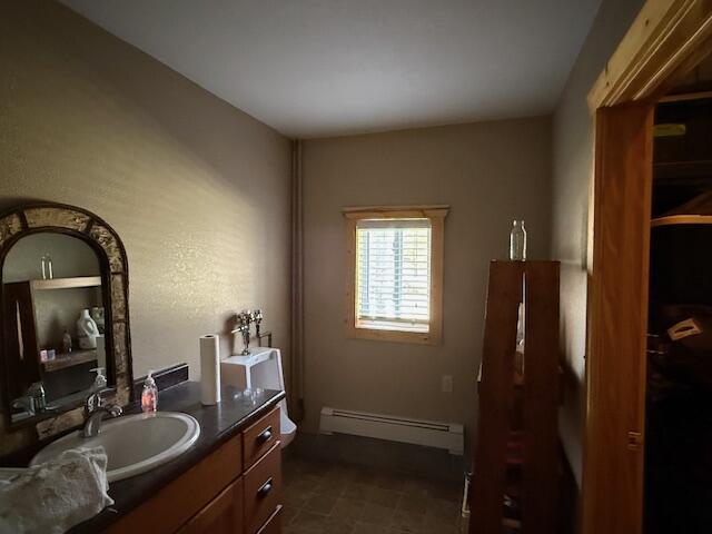 bathroom with vanity, a baseboard radiator, and toilet