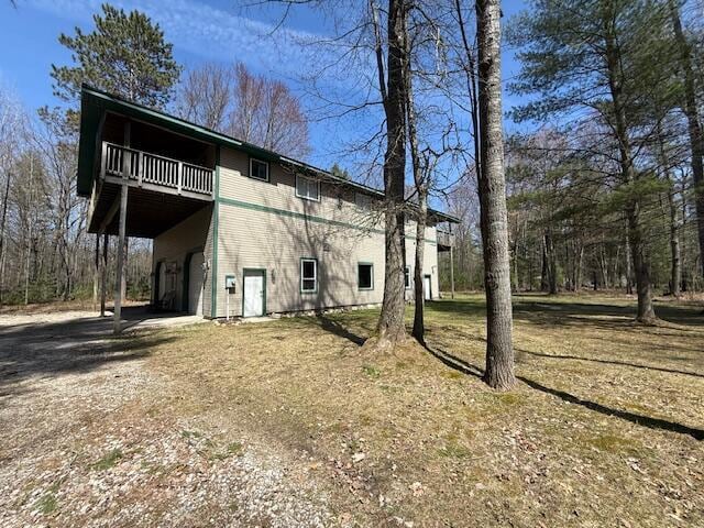 view of side of property featuring dirt driveway, a deck, and a garage