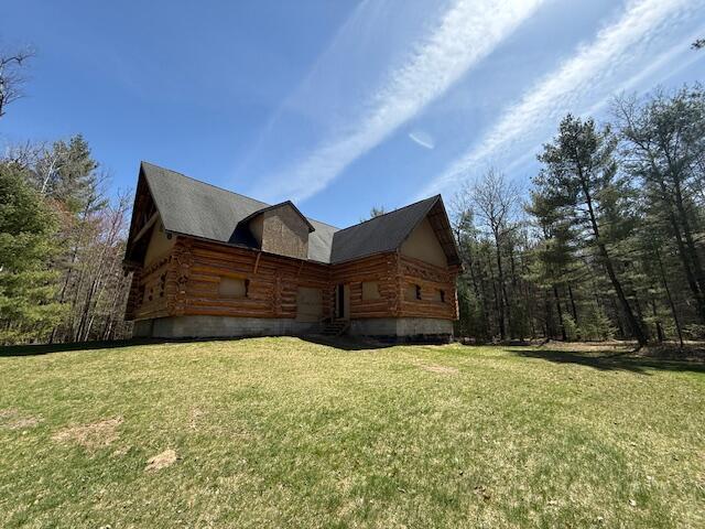 view of side of property with a lawn and log exterior