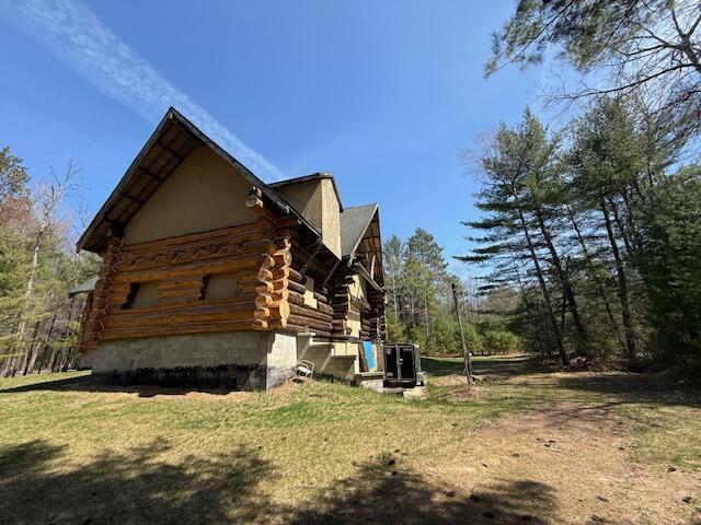 view of home's exterior featuring a yard and log exterior