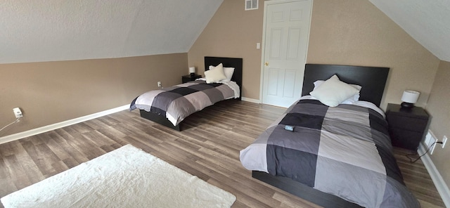 bedroom with visible vents, baseboards, wood finished floors, and vaulted ceiling