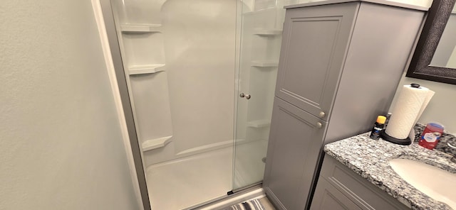 full bath with a shower stall and vanity