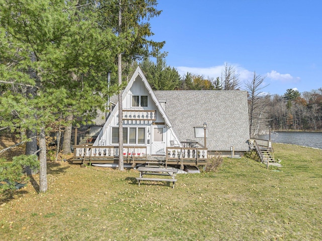 2047 W Martin Lake Rd, Gaylord, MI 49735 - back of property with a yard, a deck with water view, and roof with shingles