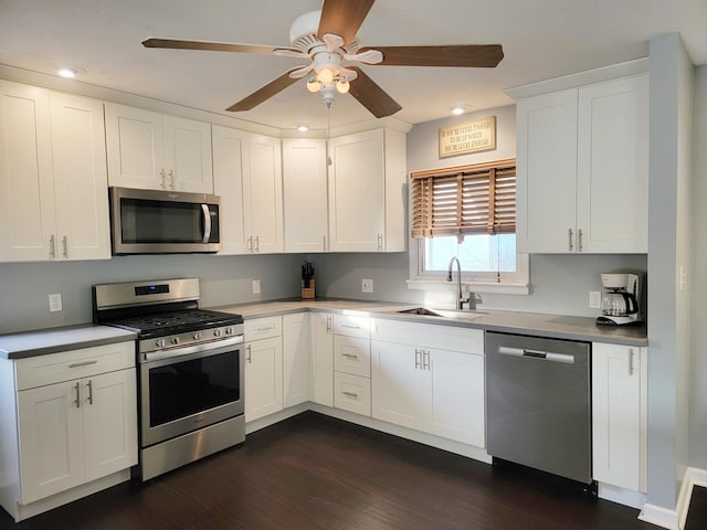 kitchen with stainless steel appliances, ceiling fan, dark wood finished floors, and a sink