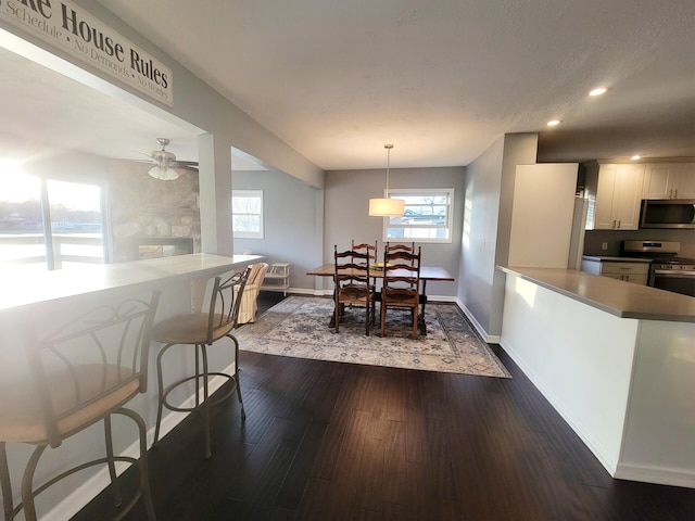 dining room with recessed lighting, baseboards, ceiling fan, and dark wood-style flooring