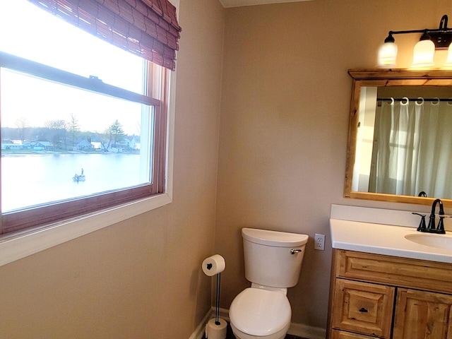 bathroom with vanity, baseboards, curtained shower, and toilet