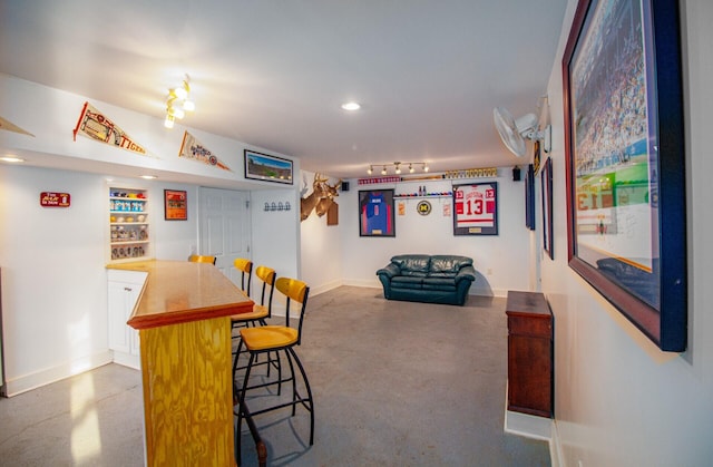 bar featuring finished concrete flooring, baseboards, and recessed lighting