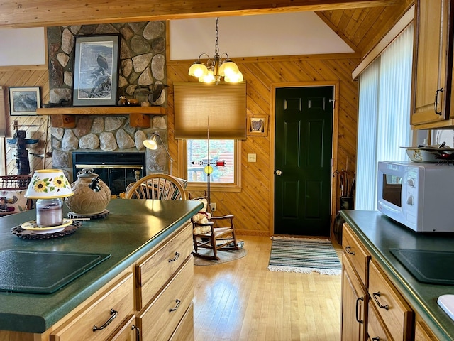 kitchen featuring white microwave, wooden walls, and dark countertops