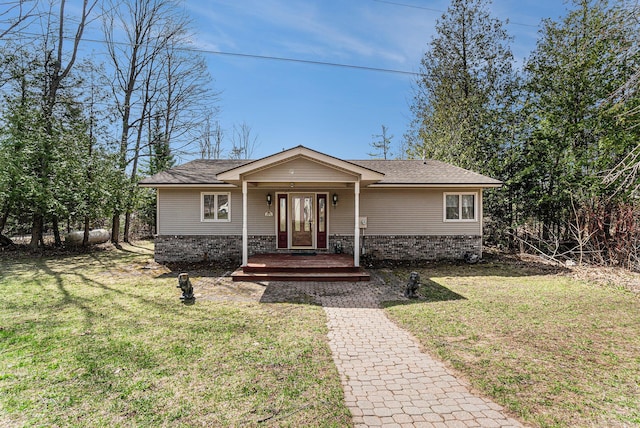 view of front of home with brick siding, roof with shingles, and a front yard