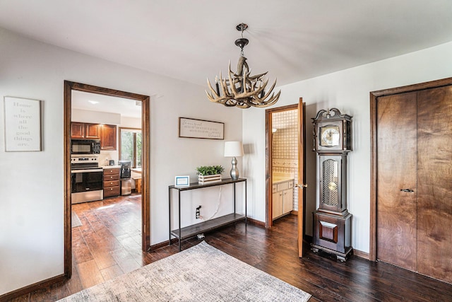 9860 Bingham Rd, Elmira, MI 49730 - interior space featuring baseboards, a chandelier, and dark wood-type flooring