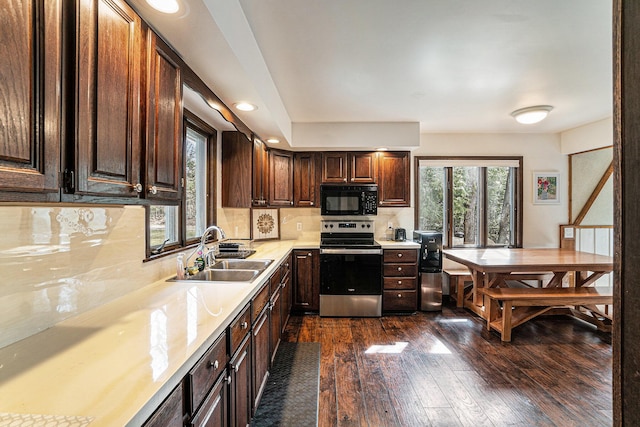kitchen featuring black microwave, a sink, light countertops, electric stove, and dark wood-style floors