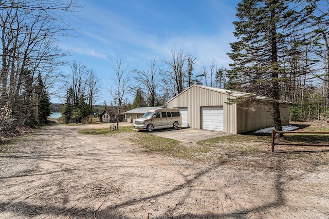 detached garage featuring dirt driveway