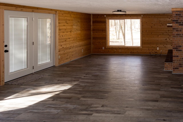 234 Pocahontas Ave, Roscommon, MI 48653 - unfurnished living room with dark wood-style flooring, a textured ceiling, and wooden walls