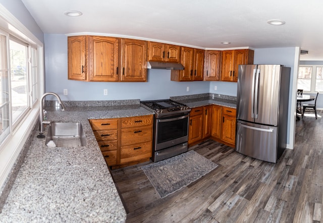 234 Pocahontas Ave, Roscommon, MI 48653 - kitchen with a sink, brown cabinetry, under cabinet range hood, and appliances with stainless steel finishes