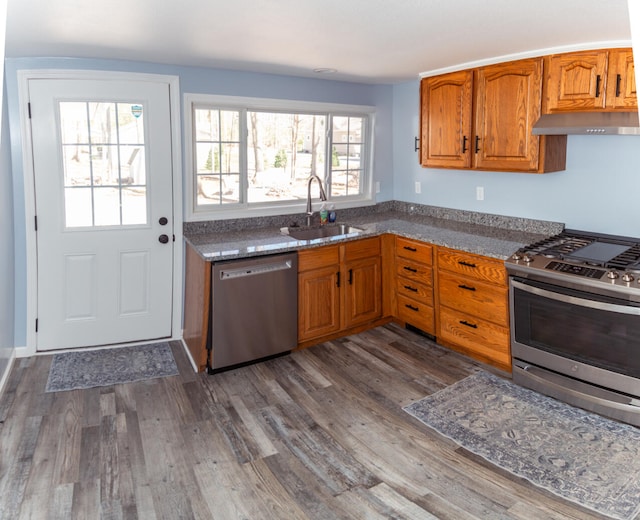 234 Pocahontas Ave, Roscommon, MI 48653 - kitchen with a sink, stainless steel appliances, brown cabinets, under cabinet range hood, and dark wood-style floors