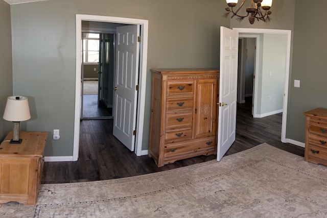 234 Pocahontas Ave, Roscommon, MI 48653 - bedroom featuring a chandelier, baseboards, and wood finished floors