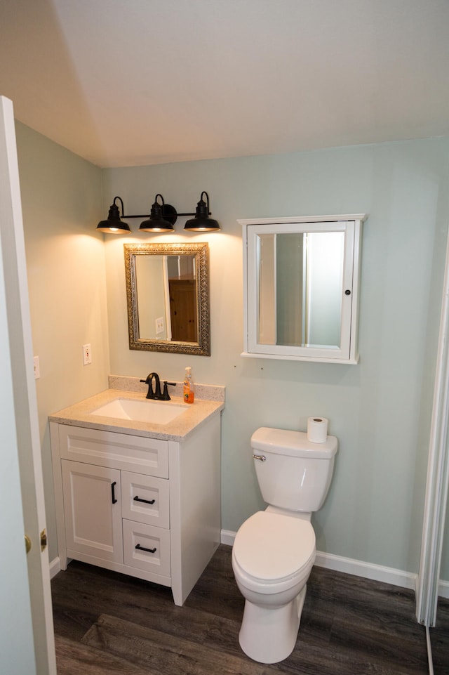 234 Pocahontas Ave, Roscommon, MI 48653 - bathroom with vanity, wood finished floors, baseboards, and toilet