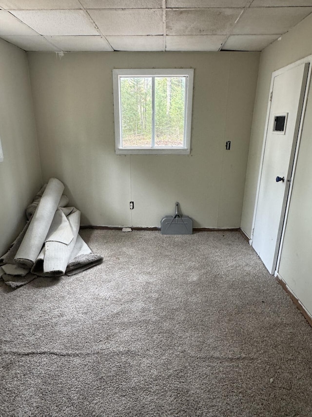 unfurnished room with carpet floors, a paneled ceiling, and baseboards