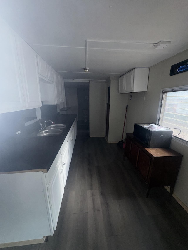 kitchen with a sink, white cabinets, and dark wood finished floors