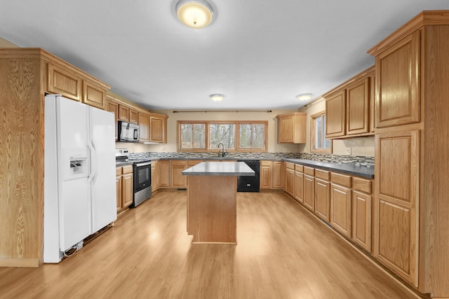 207 Cindy Ave, Roscommon, MI 48653 - kitchen with black appliances, light wood finished floors, a sink, and a kitchen island